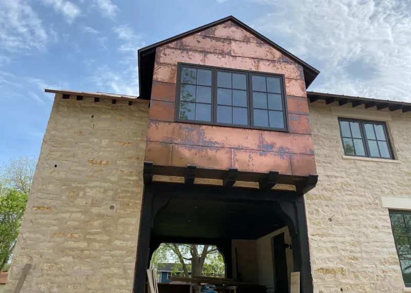 Copper metal panel facade on a stone building for Roof Repair in Emporia